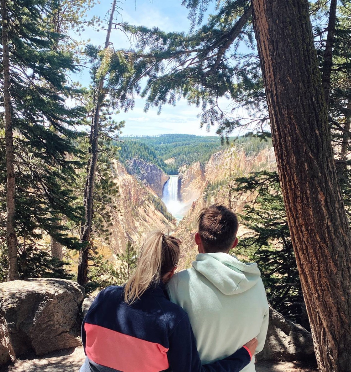 Patricia and Nikolas looking out at a waterfall in a canyon